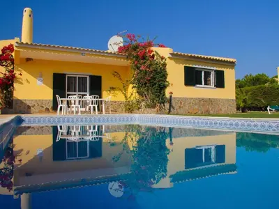 a house with a swimming pool in front of a house at Quinta Vita - Vila Maça in Loulé