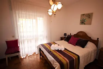 a bedroom with a bed with two white shoes on it at Apartamento Brás in Quarteira