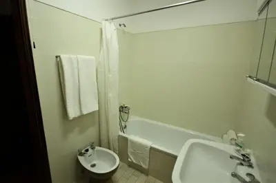 a white bathroom with a sink and a toilet at Apartamento Brás in Quarteira