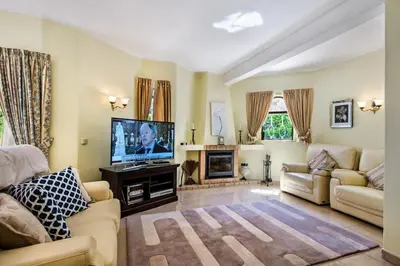 a living room with a tv and a couch and a fireplace at Amizade by Algarve Villa Holidays in Albufeira