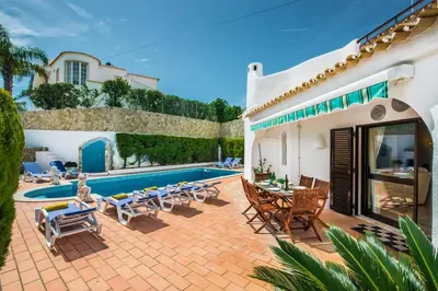 a patio with chairs and a swimming pool at Amizade by Algarve Villa Holidays in Albufeira