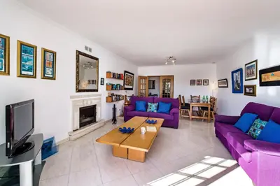 a living room with purple couches and a tv at Apt O Monte AG by Algarve Villa Holidays in Albufeira