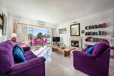 a living room with two purple couches and a tv at Apt O Monte AG by Algarve Villa Holidays in Albufeira
