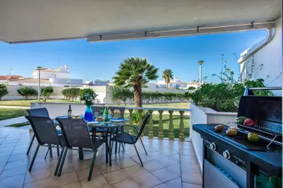 a patio with a table and chairs and a kitchen at Apt O Monte C near the beach by Algarve Villa Holidays in Albufeira