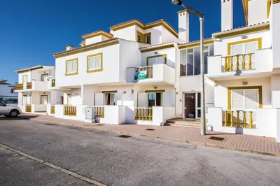 a row of white apartment buildings on a street at Apt O Monte C near the beach by Algarve Villa Holidays in Albufeira
