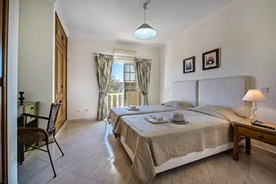 a bedroom with a bed and a table and a desk at Apt O Monte C near the beach by Algarve Villa Holidays in Albufeira