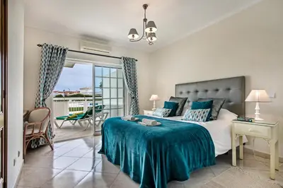 a bedroom with a bed with a blue blanket at Apt O Monte S by Algarve Villa Holidays in Galé