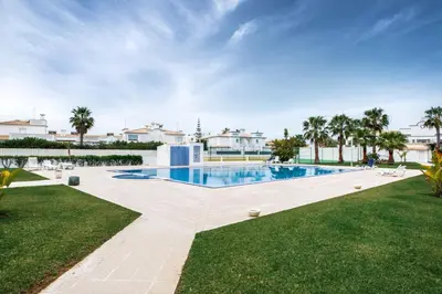 a swimming pool in a yard with palm trees at Apt O Monte S by Algarve Villa Holidays in Galé