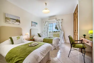 two beds in a room with a desk and a window at Apt O Monte S by Algarve Villa Holidays in Galé