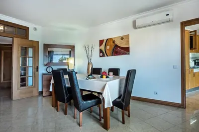 a dining room with a white table and black chairs at Apt Galé Mar 11 by Algarve Villa Holidays in Galé