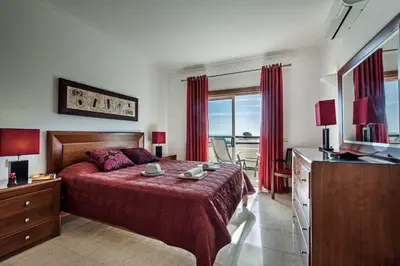 a bedroom with a bed with a red bedspread at Apt Galé Mar 11 by Algarve Villa Holidays in Galé