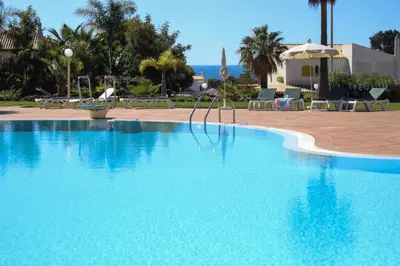 a large blue swimming pool next to a resort at Apt Galé Mar 11 by Algarve Villa Holidays in Galé