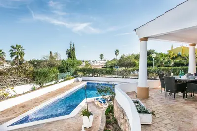 an outdoor patio with a pool and a table and chairs at Buganvilia by Algarve Villa Holidays in Guia