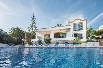 a villa with a swimming pool in front of a house at Buganvilia by Algarve Villa Holidays in Guia
