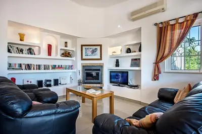 a living room with two leather couches and a tv at Buganvilia by Algarve Villa Holidays in Guia