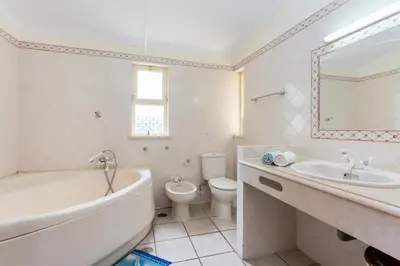 a bathroom with a tub and a sink and a toilet at Helmar by Algarve Villa Holidays in Galé