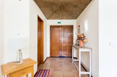 a hallway with a wooden door and a tiled floor at Helmar by Algarve Villa Holidays in Galé