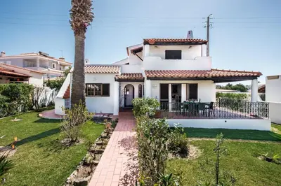 a white house with a palm tree in the yard at Íris by Algarve Villa Holidays in Galé