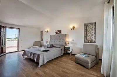 a bedroom with a bed and a chair at Isabel by Algarve Villa Holidays in Galé