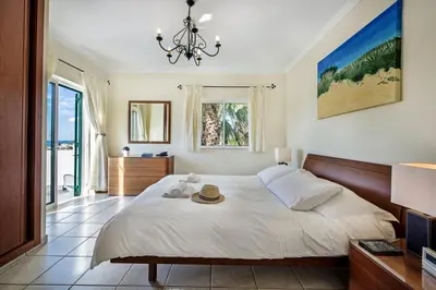 a bedroom with a large bed and a chandelier at Julieta by Algarve Villa Holidays in Galé