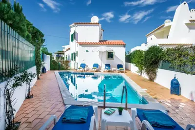 a villa with a swimming pool in front of a building at Julieta by Algarve Villa Holidays in Galé
