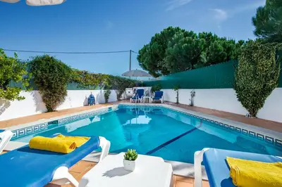 a swimming pool with two tables and chairs next to a house at Julieta by Algarve Villa Holidays in Galé