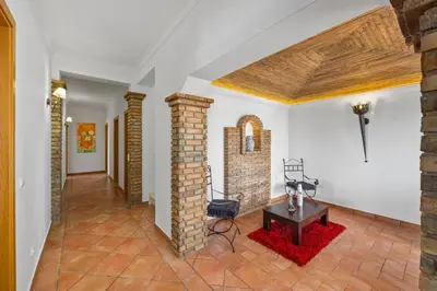 a living room with a brick fireplace and a table at Laura by Algarve Villa Holidays in Albufeira