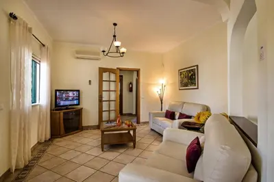a living room with a couch and a tv at Rebela by Algarve Villa Holidays in Galé