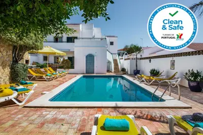a villa with a swimming pool with a sign that says clean and safe at Rebela by Algarve Villa Holidays in Galé