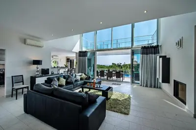 a living room with black furniture and a large window at Vista Mar by Algarve Villa Holidays in Sesmarias