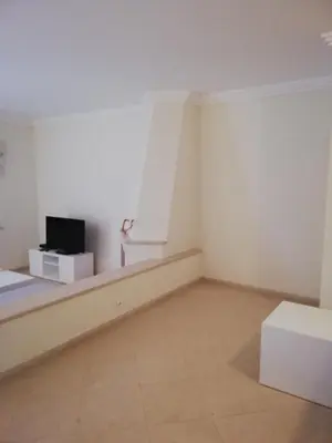 a white room with a tv and a couch at Villa V2 C in Albufeira