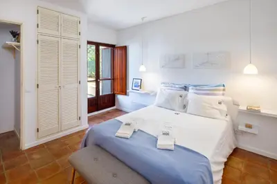 a bedroom with a large bed with two scales on it at Pura Vida Falésia by The Portuguese Butler in Albufeira