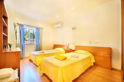 a hotel room with two beds and a window at Vivenda Gabriel #vivgabriel in Albufeira