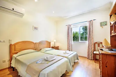 a bedroom with two beds and a window at Vivenda Gabriel #vivgabriel in Albufeira