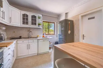 a kitchen with white cabinets and a refrigerator at Vila da Encosta - Private - Heated swimming pool - By bedzy in Albufeira