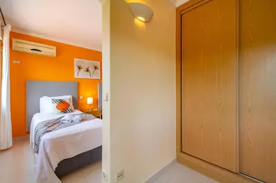 a bedroom with a bed and an orange wall at Vila da Encosta - Private - Heated swimming pool - By bedzy in Albufeira