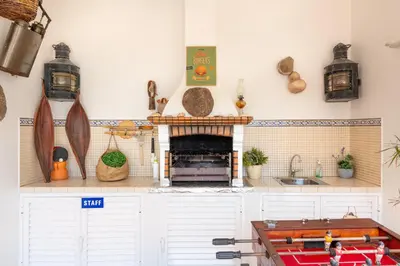 a kitchen with white cabinets and a fireplace at Vila da Encosta - Private - Heated swimming pool - By bedzy in Albufeira