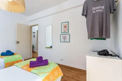 a room with two beds and a shirt hanging on a wall at Magic Theatre Faro Center in Faro