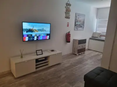 a living room with a flat screen tv on a wall at GA-DAL Stay Inn in Albufeira