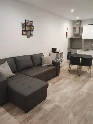 a living room with a couch and a kitchen at GA-DAL Stay Inn in Albufeira
