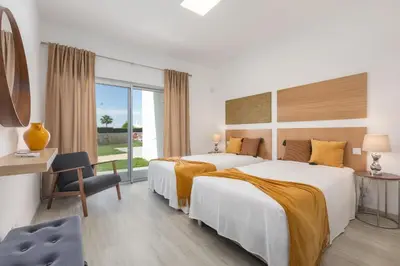 a hotel room with two beds and a desk at Villa Alfazema - heatable pool in Albufeira