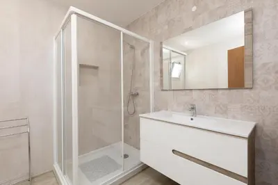 a bathroom with a shower and a sink and a mirror at Villa Alfazema - heatable pool in Albufeira