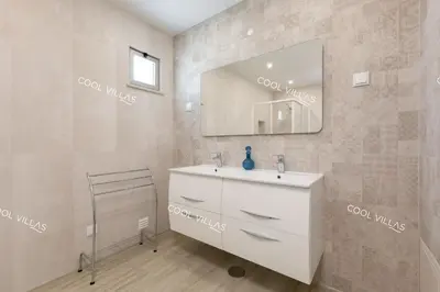 a bathroom with a white sink and a mirror at Villa Alfazema - heatable pool in Albufeira