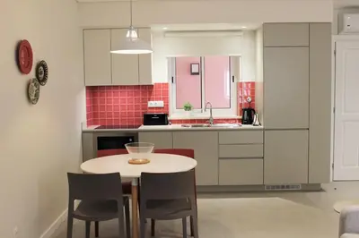 a kitchen with a table and chairs in a room at Cardeal Suites & Apartments in Faro