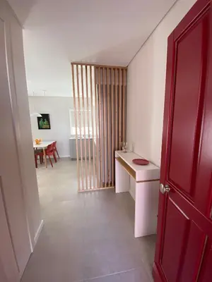 a room with a red door and a table in it at Cardeal Suites & Apartments in Faro