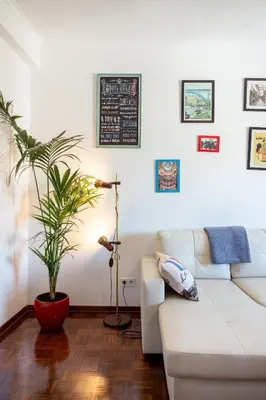 a living room with a white couch and a plant at Dreamers Duplex with Seaview in Faro