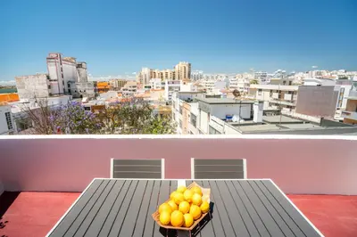a bowl of oranges sitting on a table on a balcony at Dreamers Duplex with Seaview in Faro