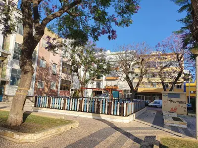 a fence in front of some buildings with trees at Dreamers Duplex with Seaview in Faro