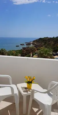a white table and chairs with a view of the ocean at Oura Ocean Front in Albufeira
