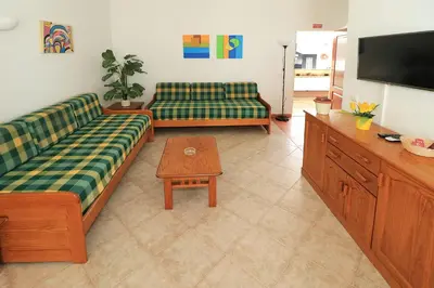 a living room with two couches and a television at Oura Ocean Front in Albufeira